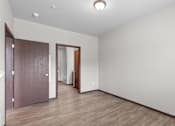 Thumbnail 14 of 50 - A room with a brown door and a white wall.