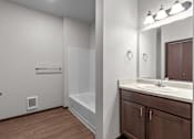 Thumbnail 15 of 50 - A bathroom with a white sink and a brown cabinet.