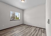 Thumbnail 37 of 50 - A room with a window and wooden flooring.