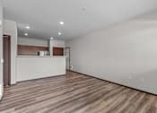 Thumbnail 33 of 50 - A spacious room with wooden flooring and white walls.