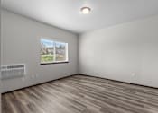 Thumbnail 34 of 50 - A room with a window and a wooden floor.