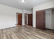Thumbnail 35 of 50 - A room with wooden floors and three brown doors.