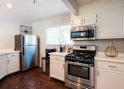 Thumbnail 8 of 18 - A kitchen with a stainless steel refrigerator, oven, and microwave.