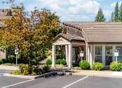 Thumbnail 13 of 18 - A building with a brown roof and a parking lot in front.