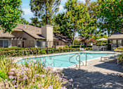 Thumbnail 2 of 18 - A pool surrounded by a patio and trees.