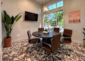 Thumbnail 22 of 24 - a conference room with a round table and chairs and a television