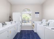 Thumbnail 30 of 33 - a laundry room with white washers and dryers and a window