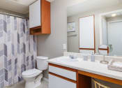 Thumbnail 12 of 33 - a bathroom with a white toilet next to a sink and a mirror