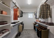Thumbnail 10 of 31 - a walk in closet filled with clothes and shoes