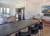 Thumbnail 20 of 27 - Modern kitchen with a long wooden table and chairs at The Arvon, Vancouver, WA 98662