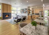 Thumbnail 12 of 23 - A modern living room with a fireplace and a dining table.