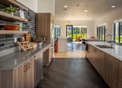 Thumbnail 33 of 34 - A modern kitchen with wooden cabinets and a large island at The Arvon, Vancouver