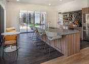 Thumbnail 32 of 34 - A modern kitchen with a wooden island and grey chairs at The Arvon, Vancouver, WA
