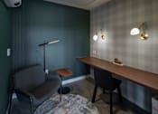 Thumbnail 27 of 34 - A room with a chair, a table, and a lamp.