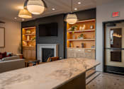 Thumbnail 27 of 34 - A modern kitchen with a marble countertop and a fireplace.