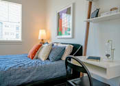 Thumbnail 18 of 28 - a bedroom with a bed and a desk with a chair