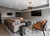 Thumbnail 20 of 35 - A modern living room with a grey sofa and a black and white rug.
