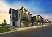 Thumbnail 32 of 54 - a row of houses with lights on at dusk