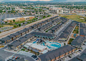 Thumbnail 31 of 32 - A large residential complex with a swimming pool and a parking lot.
