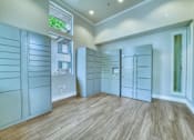 Thumbnail 51 of 52 - A room with wooden floors and white walls, featuring a row of white cabinets and a window.