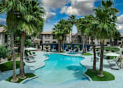 Thumbnail 46 of 52 - A swimming pool surrounded by palm trees and lounge chairs.