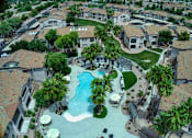 Thumbnail 44 of 52 - A swimming pool surrounded by palm trees and houses.
