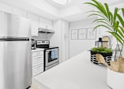 Thumbnail 2 of 21 - a white kitchen with stainless steel appliances and white countertop at Connect on Union apartments near Deer Valley.