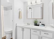 Thumbnail 8 of 21 - a white bathroom with a sink and a mirror