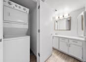Thumbnail 9 of 21 - a white laundry room with a washer and dryer and a sink