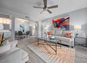 Thumbnail 10 of 21 - a living room with a couch and a ceiling fan
