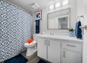 Thumbnail 13 of 21 - a bathroom with blue and white wallpaper and a white toilet and sink