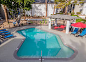 Thumbnail 19 of 21 - a resort style pool with a red umbrella and chairs around it