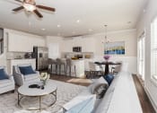 Thumbnail 3 of 60 - a living and kitchen area with a ceiling fan and couches