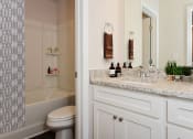 Thumbnail 11 of 60 - a bathroom with white cabinets and a black and white shower curtain