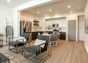 Thumbnail 24 of 26 - A modern kitchen with a dining area and a refrigerator.