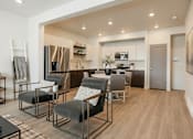 Thumbnail 2 of 20 - A modern kitchen with a dining area and a refrigerator.