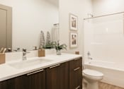 Thumbnail 15 of 20 - A bathroom with a white sink and a white toilet.