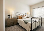 Thumbnail 13 of 20 - A bedroom with a bed, nightstand, and window.