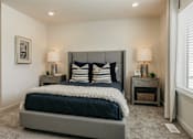 Thumbnail 10 of 20 - A bedroom with a large bed and two nightstands.