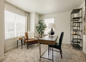 Thumbnail 16 of 20 - A living room with a brown chair and a wooden table.