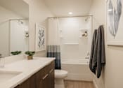 Thumbnail 14 of 20 - A bathroom with a white countertop and a white sink.