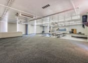 Thumbnail 24 of 25 - A large, empty room with a checkered floor and white walls.