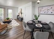 Thumbnail 5 of 23 - A dining room with a table set for two and a painting on the wall.