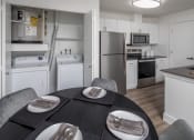 Thumbnail 7 of 38 - Kitchen with white appliances and a dining table with plates and chairs at Arbor Heights, Tigard, 97224