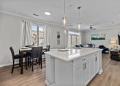 Thumbnail 5 of 21 - an open concept kitchen and living room with an island and a dining table