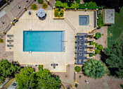 Thumbnail 3 of 18 - A pool surrounded by a patio and trees.