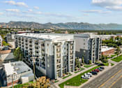 Thumbnail 29 of 30 - A large apartment building with a parking lot in front of it.