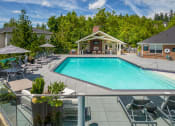 Thumbnail 25 of 38 - a swimming pool with lounge chairs and umbrellas in front of a buildingat Arbor Heights, Tigard, 97224