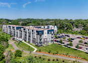 Thumbnail 30 of 35 - A large apartment complex with a parking lot in front.