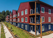 Thumbnail 30 of 34 - A red and blue building with balconies and windows.